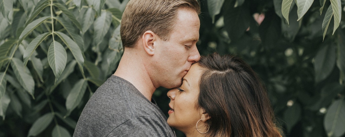 man kissing womans forehead